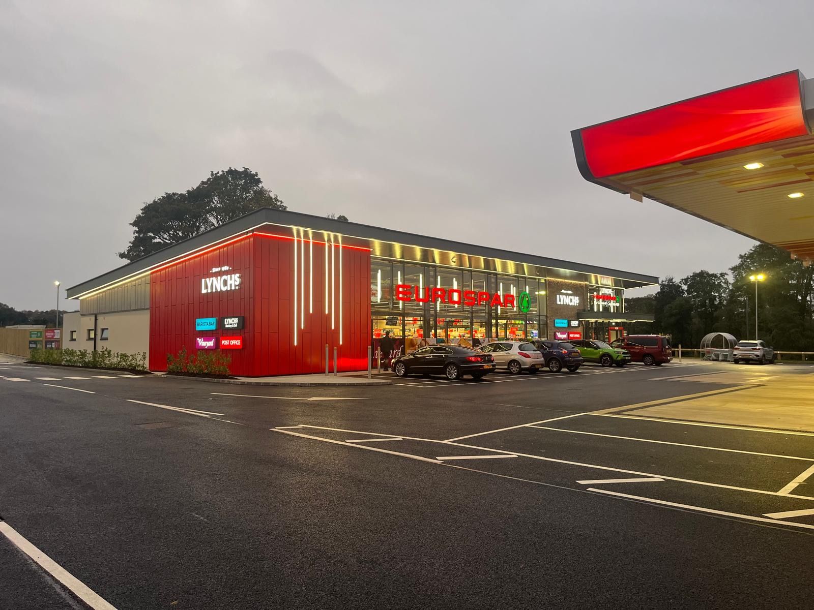 Completed commercial cladding on the Lynch's SPAR forecourt, lit up at dusk
